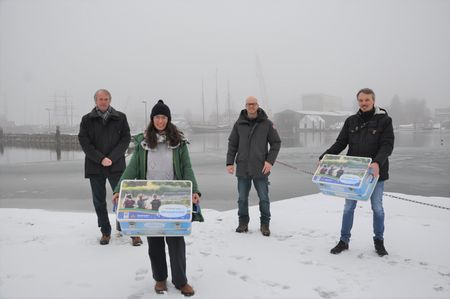 Die Brüder Greifenberg von der Firma Dampsoft übergeben dem Naturpark Schlei, vertreten durch Vorstandsvorsitzendem Jens Kolls und Projektmanagerin Michelle Dresler, zwei Gewässerforschungskoffer für den Bereich Umweltbildung. 